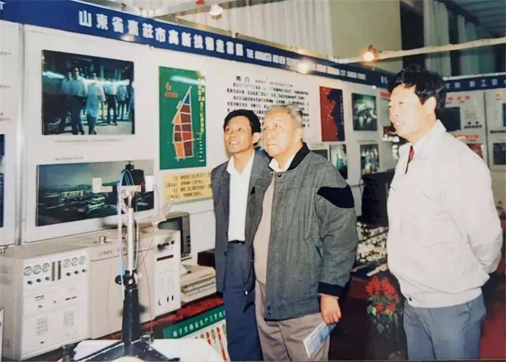 1991年,在全國高新區(qū)匯報展覽會上,吳承鑒(右一)和省科委副主任兼棗莊市副市長陸巽生(左一)陪同國家科委常務(wù)副主任李緒鄂(中)觀看棗莊高新區(qū)展區(qū).jpg